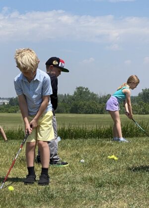 Photo of youth golfer during lessons at the driving range.